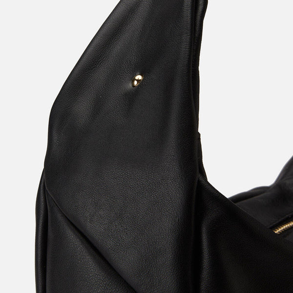 Un a sacca morbidissima nella colorazione nera realizzata in Vitello nappato. Comoda da portare a spalla mediante l'ampia fascia morbidissima. Ampia internamente, rivestita in tessuto logato con scomparto a chiusura zip. Tracolla amovibile. Elegante la metalleria color oro. Logo stampato a caldo sulla parte frontale Trattandosi di Vera Pelle trattata e rifinita artigianalmente, il vostro accessorio sarà durevole nel tempo e sempre attuale.