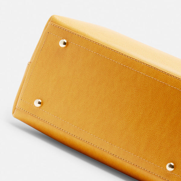 Un Secchiello Della Collezione Alice di colore Giallo sobrio ed elegante. Caratterizzato da uno spallaccio regolabile in altezza, chiusura a bottone e tasca a chiusura zip interna.